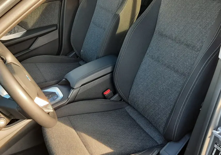 Vue intérieure rapprochée des sièges avant en tissu gris foncé de la BMW Série 1 F70 120D M Sport Design 2025.