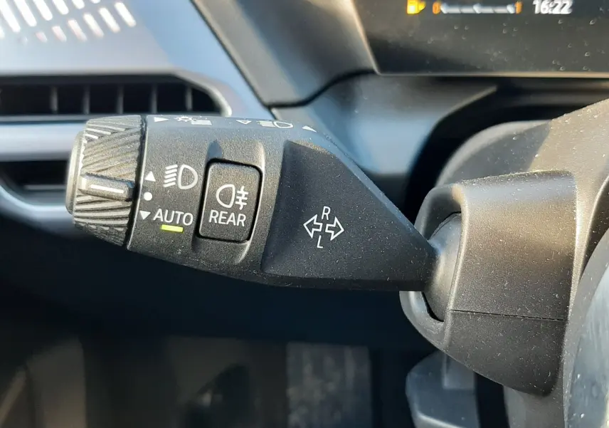 Gros plan sur la commande des feux et clignotants dans l'habitacle d'une BMW Série 1 gris Skyscraper 2025.