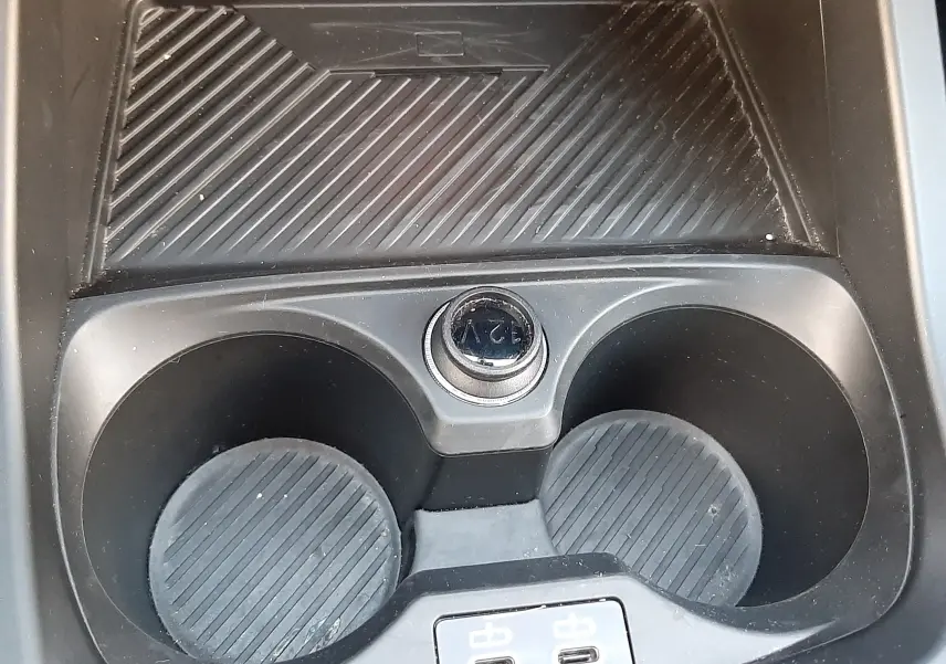Gros plan sur la console centrale noire avec porte-gobelets, prise 12V et deux ports USB-C de la BMW Série 1 F70.