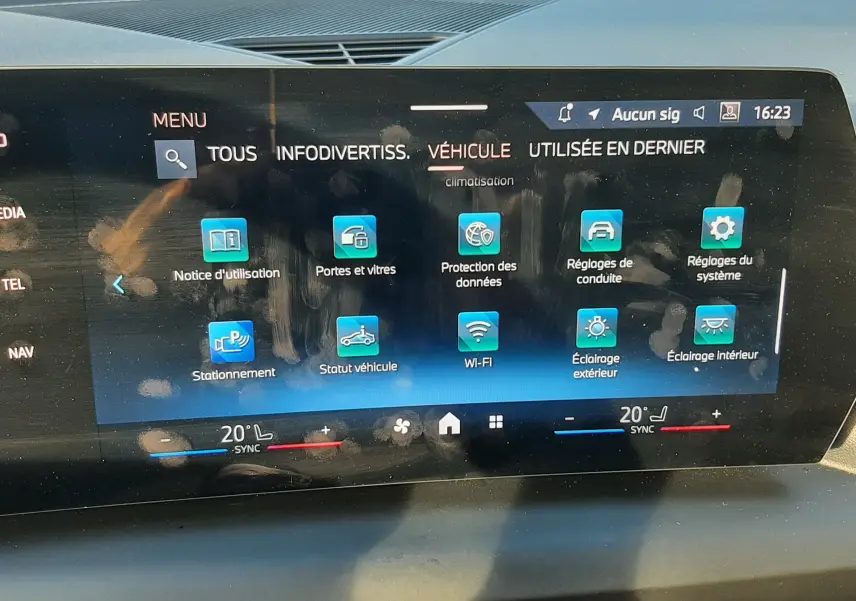 Écran tactile central de la BMW Série 1 2025 affichant le menu véhicule avec commandes climatisation et connectivité.
