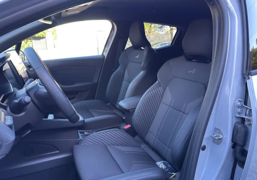 Intérieur de la Renault Clio V E-Tech 145 Esprit Alpine 2025, vue côté conducteur, sièges noirs avec logo Alpine brodé.