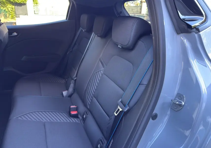 Vue intérieure côté droit des sièges arrière noirs avec surpiqûres bleues dans une Renault Clio Gris rafale 2025 Esprit Alpine.
