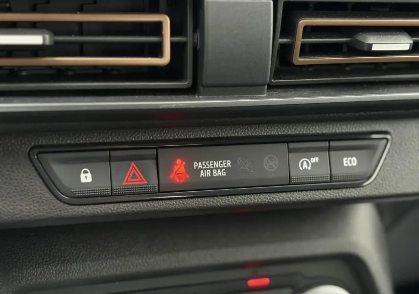 Gros plan sur la console centrale noire de la Dacia Sandero Stepway avec voyants et boutons éclairés.