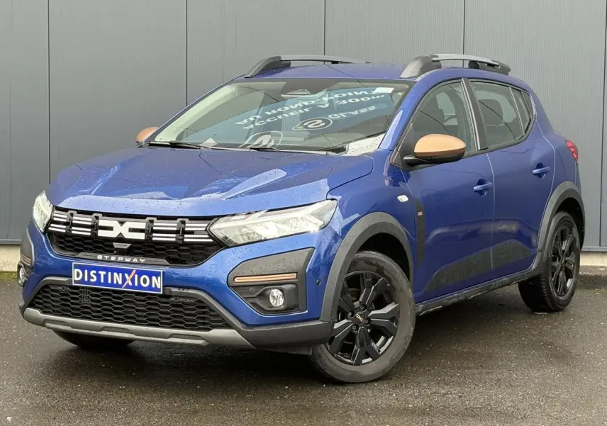 Dacia Sandero Stepway Bleu Iron en 3/4 avant droit avec jantes noires et coques de rétroviseurs cuivrées.