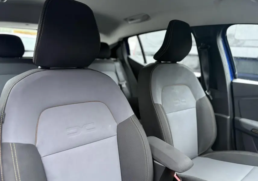 Vue intérieure des sièges avant en sellerie TEP MicroCloud gris avec surpiqûres contrastantes dans une Dacia Sandero Stepway Bleu Iron.