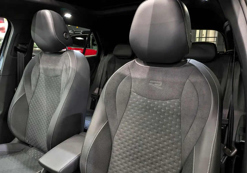 Vue intérieure rapprochée des sièges avant en cuir noir et alcantara avec logo R du Volkswagen T-Roc eTSI 2026.