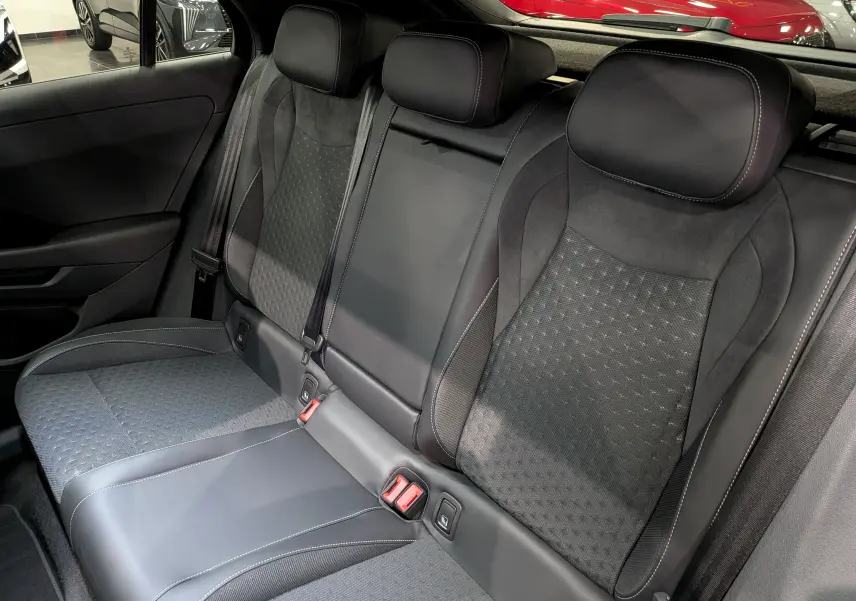 Vue intérieure des sièges arrière en cuir noir et alcantara du Volkswagen T-Roc eTSI 150 CH DSG7 R-LINE 2026, avec appuie-têtes et ceintures visibles.
