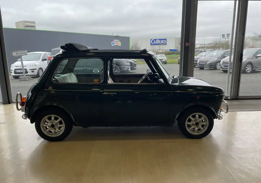 Profil côté gauche d'une MINI 1.3 i BRITISH OPEN 1995 en British Racing Green avec toit ouvrant partiellement ouvert.