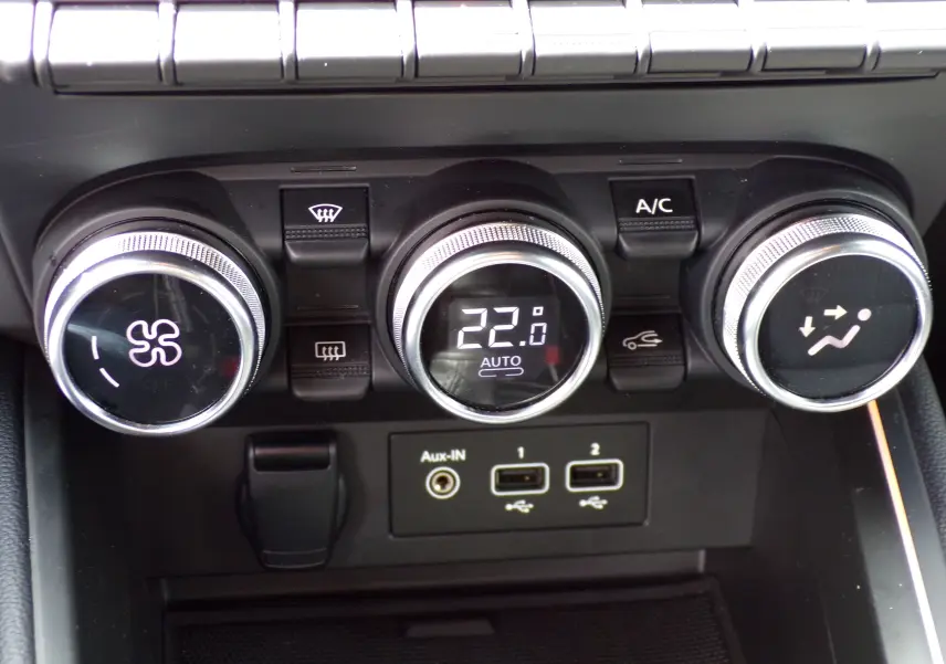 Gros plan sur les commandes de climatisation et les ports USB d'une Renault Clio V blanche, version 1.3 TCE 140 ch.