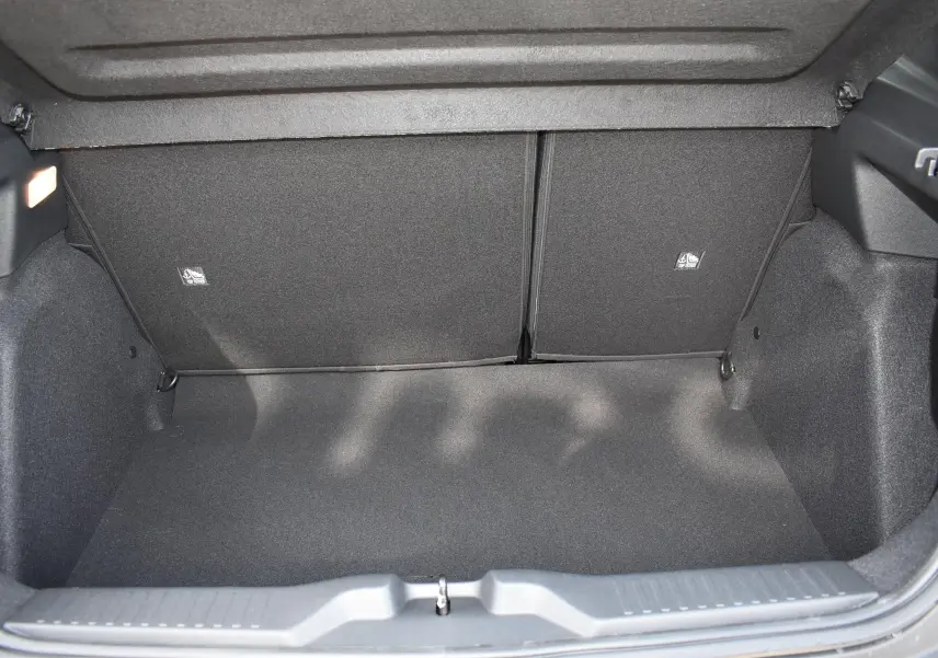 Coffre ouvert d'une Citroën C3 2025 bleu toit noir, vue intérieure montrant l'espace de rangement vide et les sièges arrière rabattables.