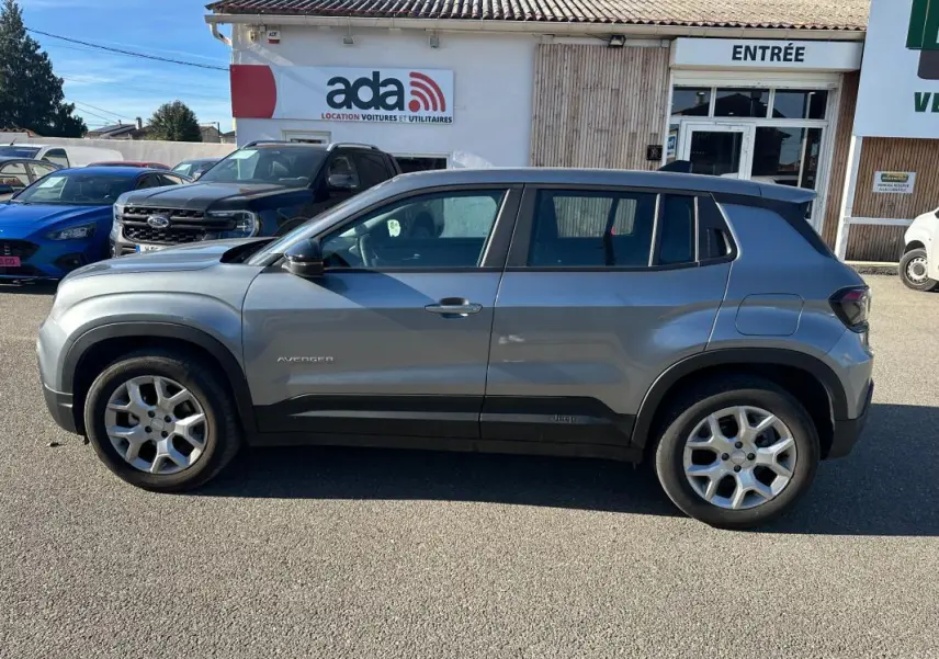 Vue de profil côté gauche d'un Jeep Avenger gris 2025 avec jantes alliage 17 pouces et toit noir contrasté.