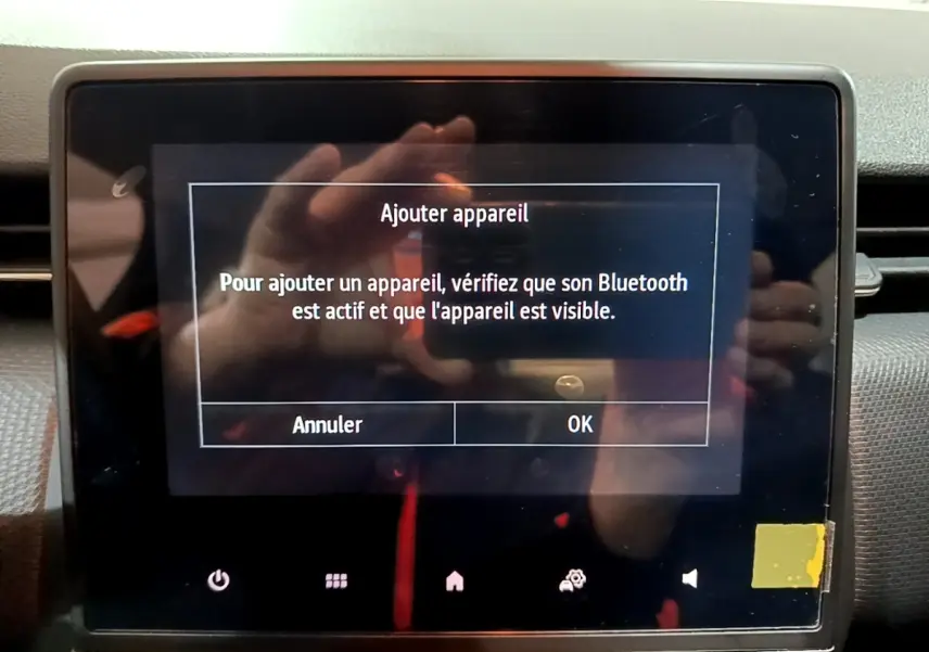 Écran tactile central de la Renault Clio gris clair 2023 affichant un message d'ajout d'appareil Bluetooth.