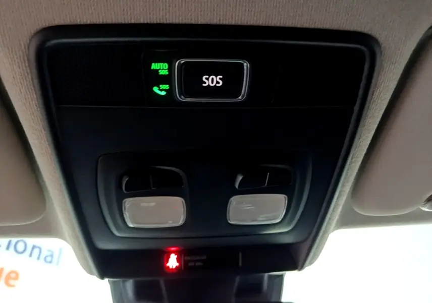 Vue intérieure en plongée sur le panneau de commande au plafond avec bouton SOS et éclairages dans une Renault Clio gris clair.