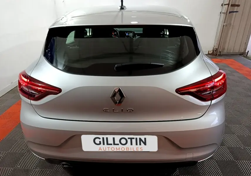 Vue arrière d'une Renault Clio gris clair 2023 avec feux LED et logo Renault bien visibles.