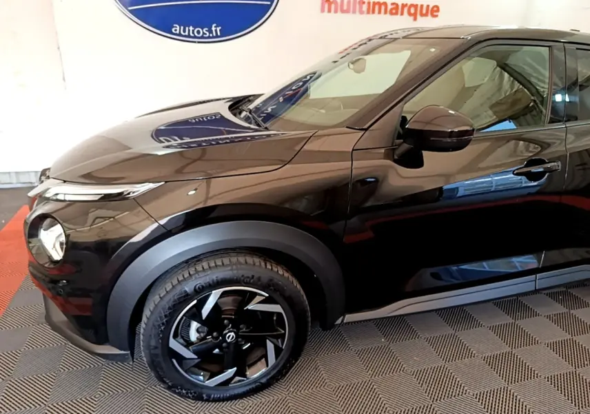 Vue de profil côté gauche du Nissan Juke DIG-T 114 DCT noir, mettant en valeur la roue avant et les rétroviseurs ton caisse.