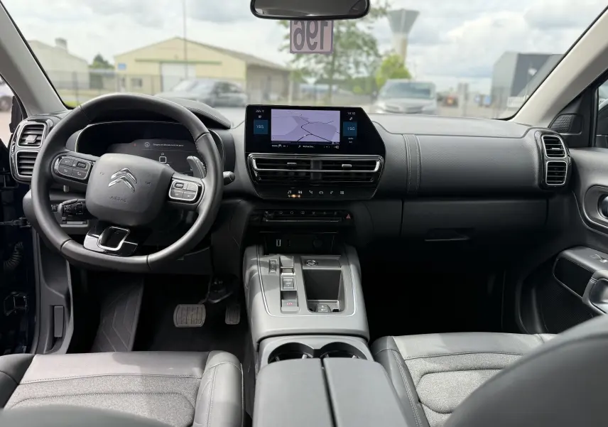 Vue intérieure avant du Citroën C5 Aircross Hybrid 145, tableau de bord moderne avec écran tactile et volant multifonction.