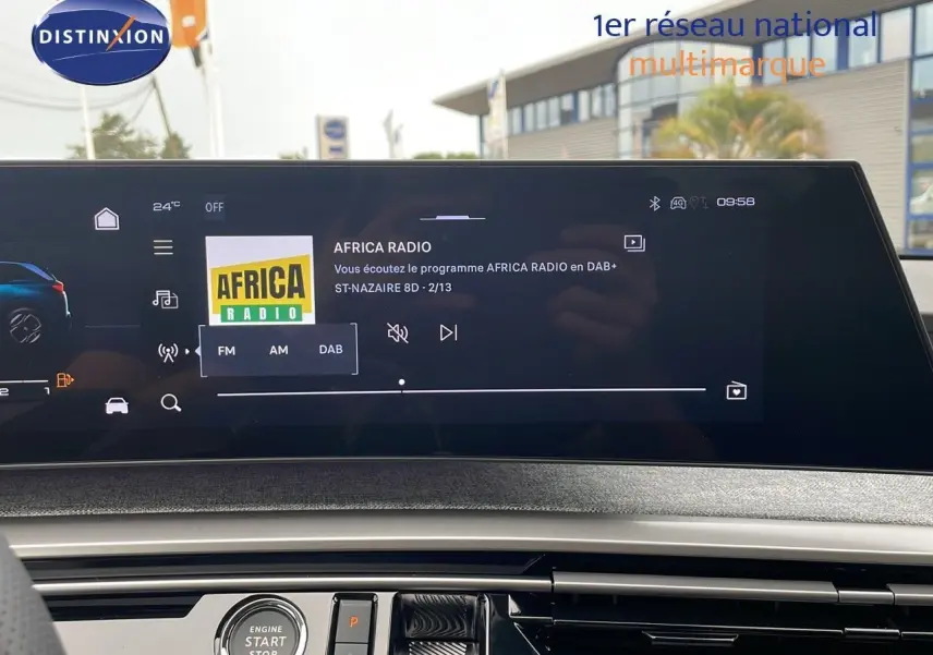 Vue intérieure du tableau de bord du Peugeot 5008 Hybrid gris avec écran tactile affichant la radio Africa Radio