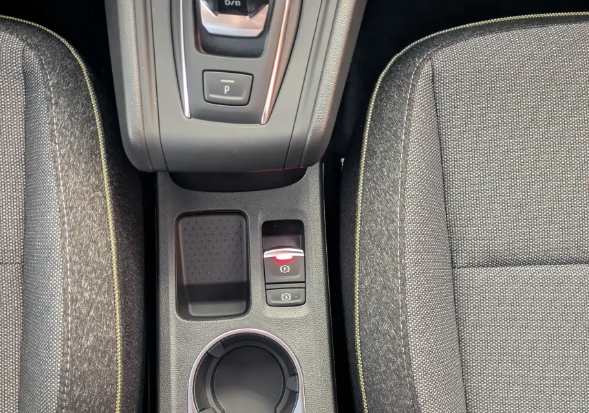 Vue plongeante sur la console centrale du Renault Captur 2025, avec levier de boîte auto et sièges gris à surpiqûres jaunes.