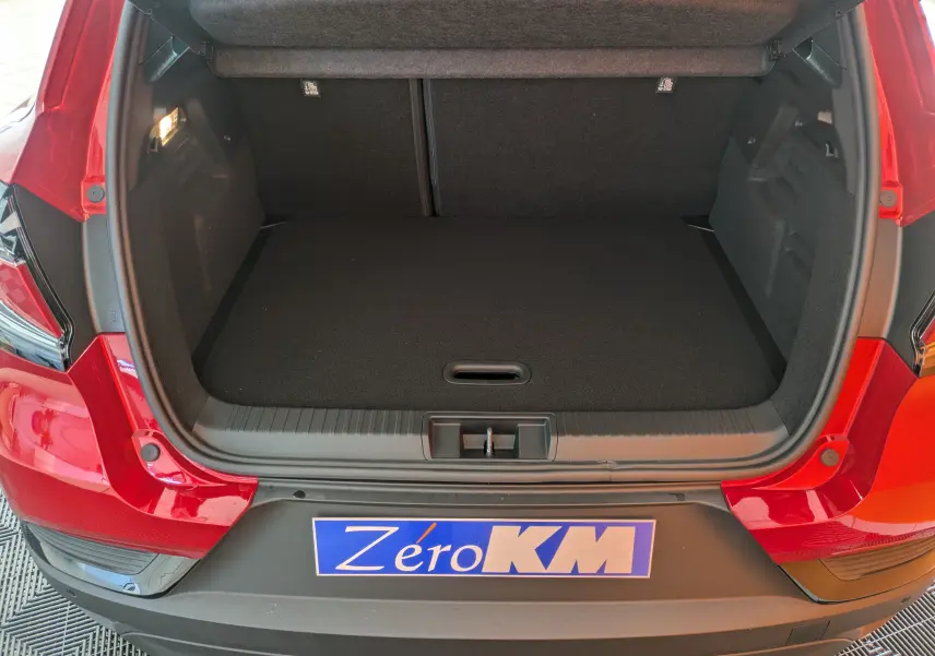 Coffre ouvert vu de l'arrière d'un Renault Captur 2025 rouge flamme toit noir, montrant l'espace de chargement vide.