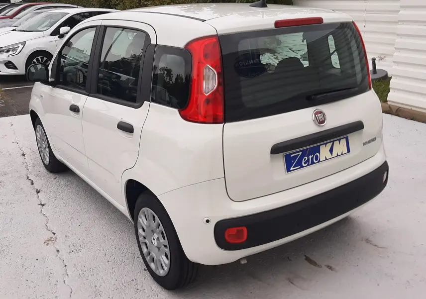 Vue 3/4 arrière droite d'une Fiat Panda blanche Gelato 2025 avec cinq portes et feux arrière verticaux distinctifs.