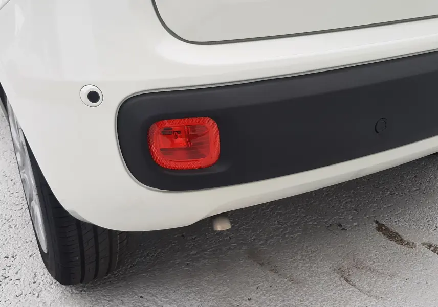 Gros plan sur le coin arrière gauche blanc gelato de la Fiat Panda 2025, avec feu antibrouillard et capteur de recul.