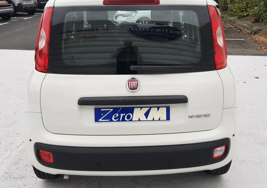 Vue arrière d'une Fiat Panda blanc gelato 2025 avec feux rouges verticaux et plaque "Zéro KM" visible.
