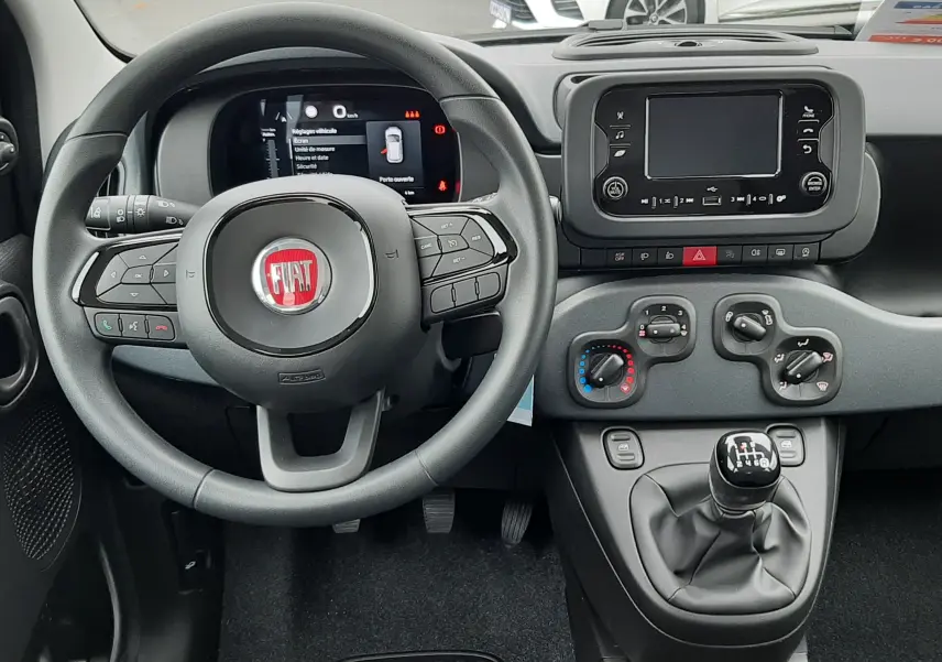 Vue intérieure du tableau de bord et volant de la Fiat Panda blanc Gelato 2025 avec boîte manuelle et écran tactile central.