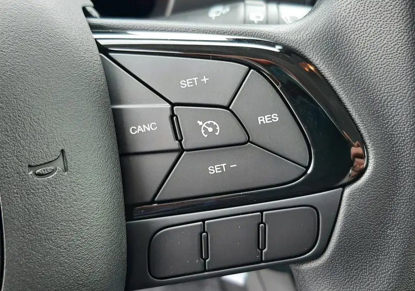 Gros plan sur les commandes de régulateur de vitesse au volant de la Fiat Panda 2025, finition noire.