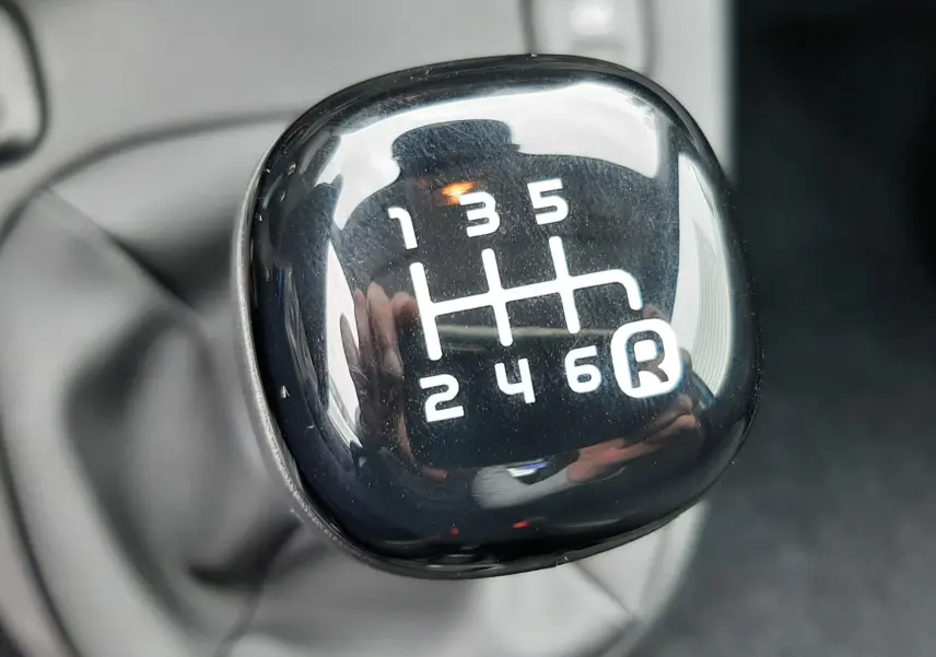 Gros plan sur le levier de vitesses manuel noir de la Fiat Panda 1.0 70CH BSG S&S, intérieur tissu noir visible.