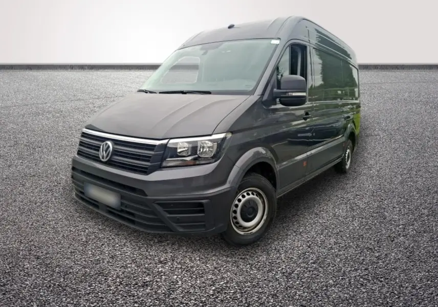 Volkswagen Crafter fourgon gris foncé vu en 3/4 avant droit sur sol gravillonné, avec jantes acier.