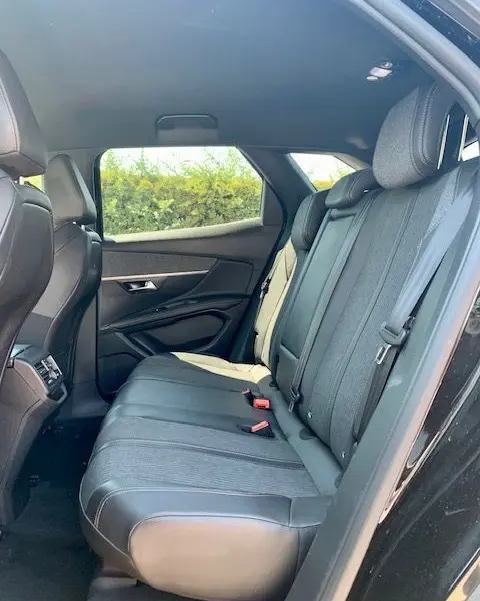Vue intérieure arrière droite du Peugeot 3008 noir 2018, montrant les sièges arrière en tissu et cuir avec ceintures de sécurité.