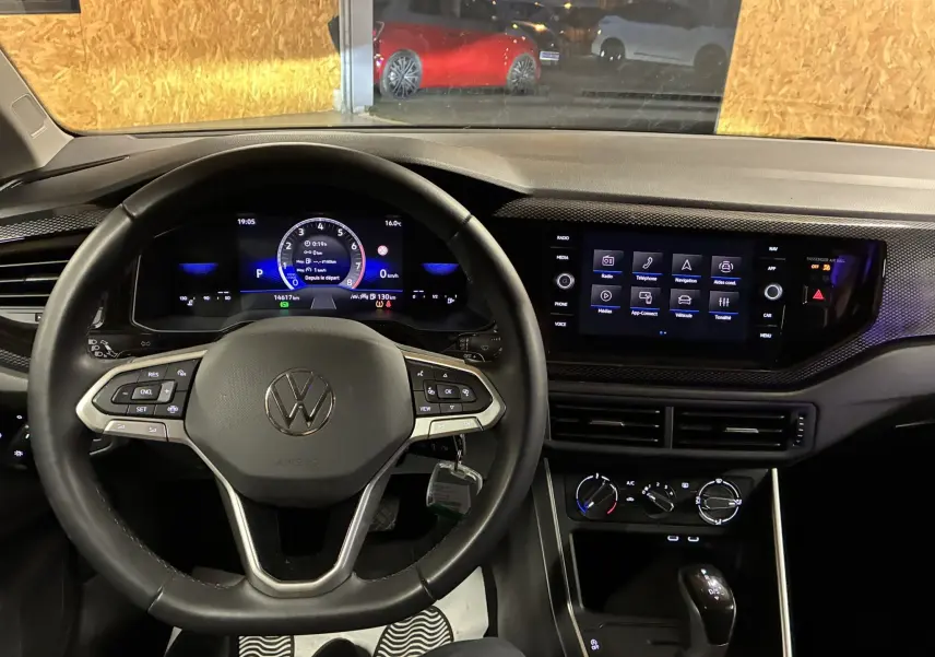 Vue intérieure frontale du tableau de bord et volant noir de la Volkswagen Polo VI 2025 avec écran digital et commandes au volant.