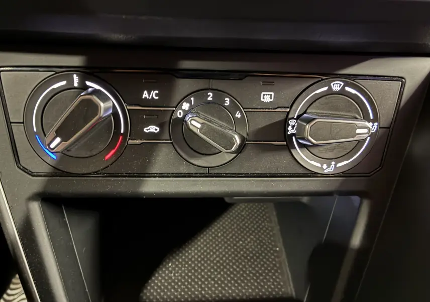 Commandes de climatisation noires en gros plan dans l'habitacle d'une Volkswagen Polo gris 2025, version Edition 50.