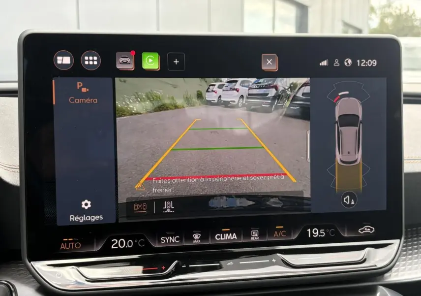 Écran tactile intérieur montrant la caméra de recul avec vue arrière et lignes de guidage jaunes.