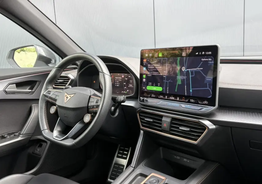 Vue intérieure côté conducteur du CUPRA Formentor 2025, tableau de bord noir avec écran tactile et volant sport cuir.