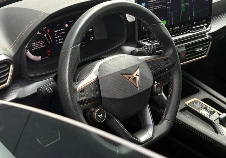 Vue rapprochée du volant cuir noir perforé avec logo CUPRA cuivre et tableau de bord numérique du Formentor.