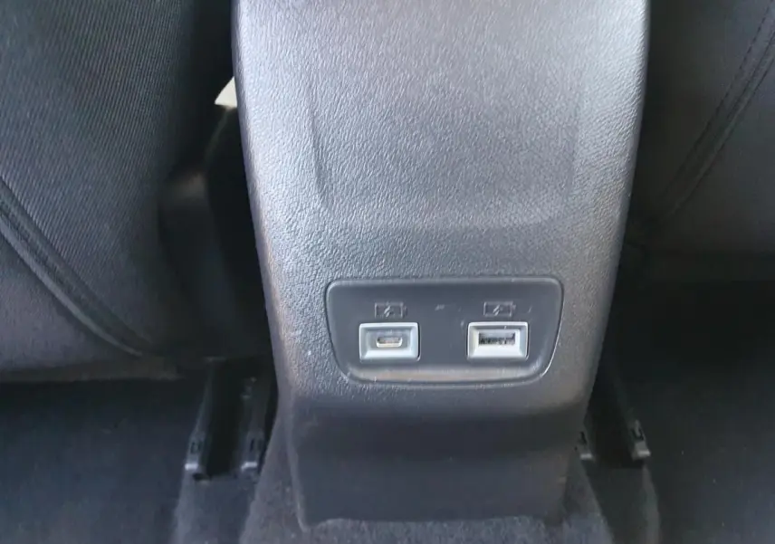 Prise USB type C et USB standard sur la console centrale arrière d'une Peugeot 208 hybride gris Sellenium.