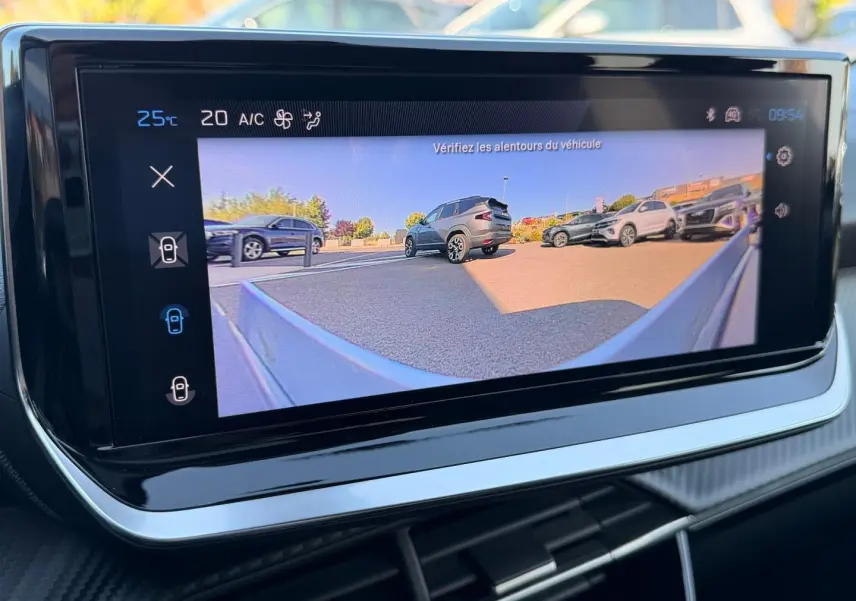 Écran tactile intérieur montrant la caméra de recul avec vue arrière sur plusieurs SUV stationnés en extérieur.