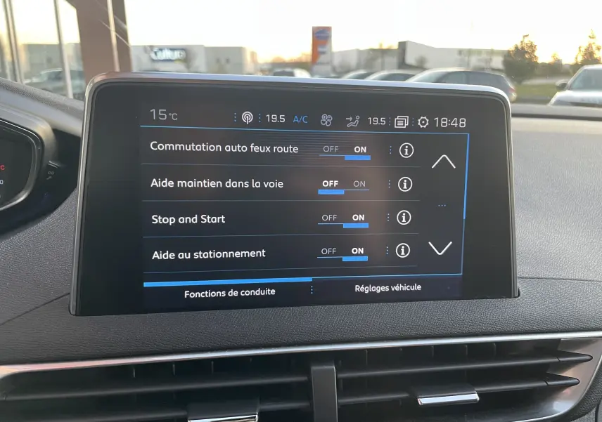 Écran central du Peugeot 3008 blanc nacré de 2019 montrant les réglages d'aides à la conduite activées.