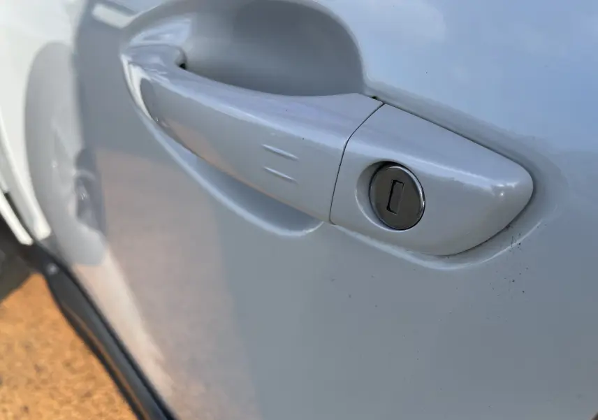 Gros plan sur la poignée de porte blanche nacrée côté gauche du Peugeot 3008 2019 avec serrure intégrée.