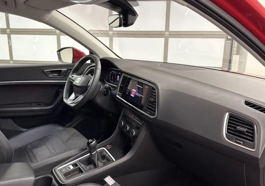Intérieur du SEAT Ateca 2024 vu côté conducteur, avec tableau de bord noir et levier de vitesse manuel.