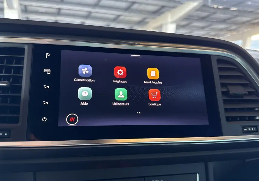 Écran tactile central avec menus climatisation et réglages dans l'habitacle du SEAT Ateca 2024 Rouge Velvet.