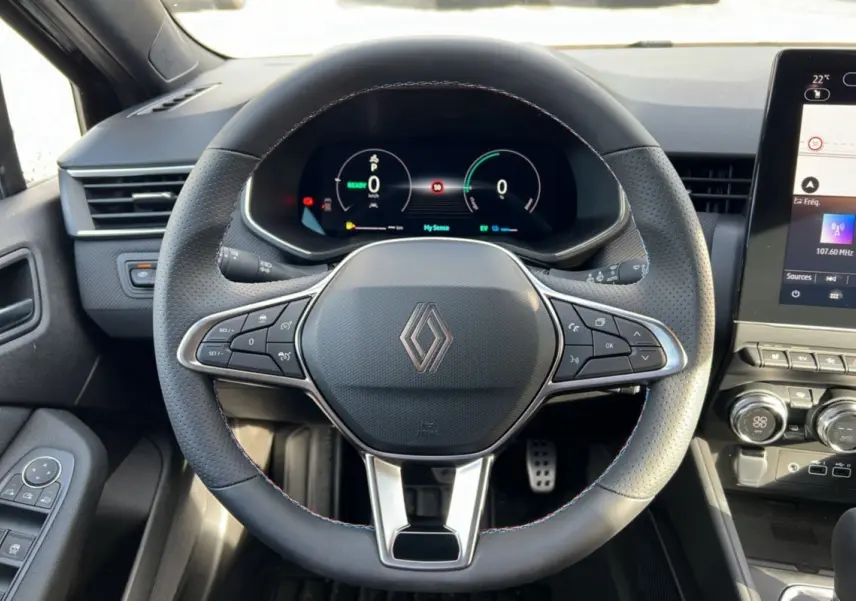 Vue rapprochée du volant et du tableau de bord numérique de la Renault Clio V E-TECH 145 Esprit Alpine 2025 en intérieur.