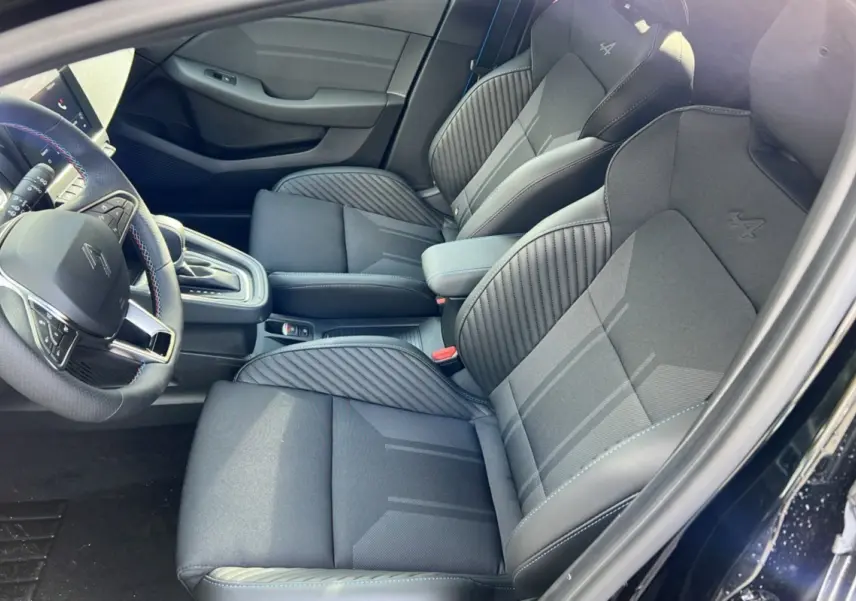 Intérieur de la Renault Clio V E-Tech 145 Esprit Alpine 2025, vue côté conducteur, sièges noirs étoilés avec logo Alpine brodé.