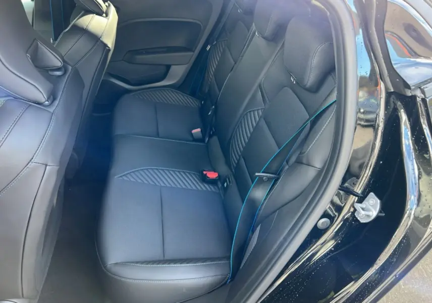 Intérieur arrière de la Renault Clio V E-Tech 145 Esprit Alpine 2025 en noir étoilé, vue côté droit avec sièges en tissu et cuir.
