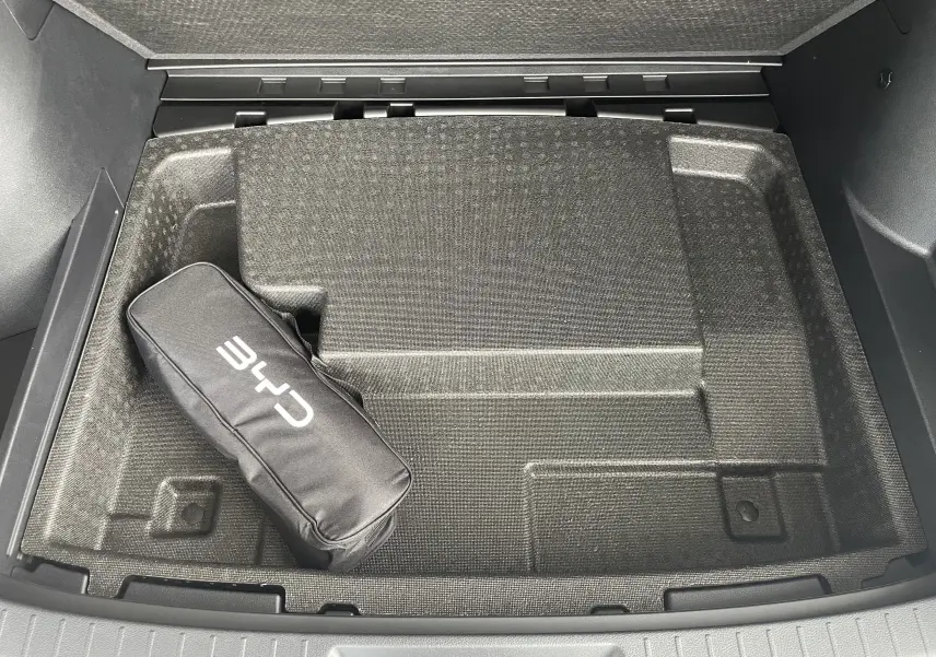 Vue plongeante sur le rangement sous plancher du coffre du BYD SEAL U 2026 en TIME GREY avec sacoche CHR noire.