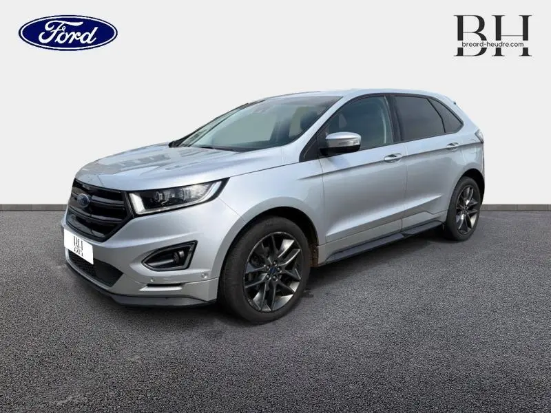 Vue 3/4 avant droite du Ford Edge gris Ingot avec jantes alliage foncé et attelage visible sous le pare-chocs arrière.