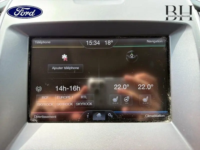 Écran tactile central du Ford Edge gris Ingot, affichant la climatisation et options multimédia, vue rapprochée.