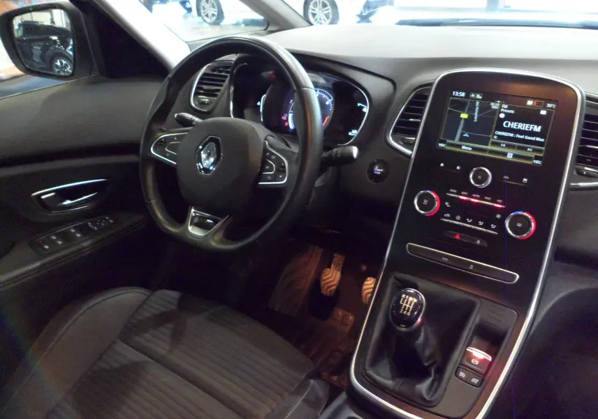 Vue intérieure côté conducteur du Renault Grand Scenic IV Business 2019, avec volant multifonction, écran tactile et boîte manuelle.