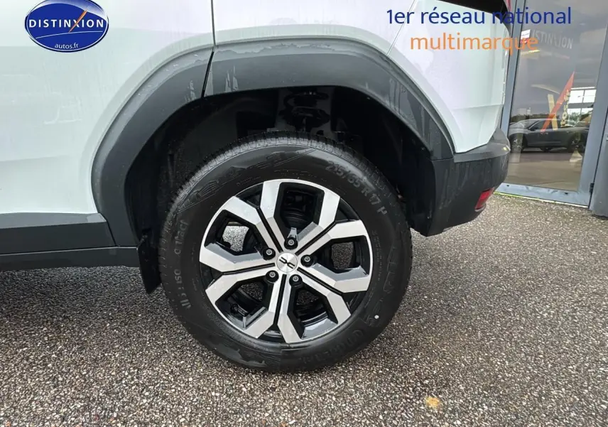 Gros plan sur la roue arrière droite du Dacia Duster blanc Arctic avec jante alu au design moderne.